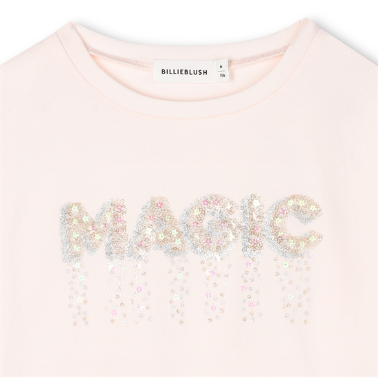 Pink top with 'MAGIC' in sequins on a white background