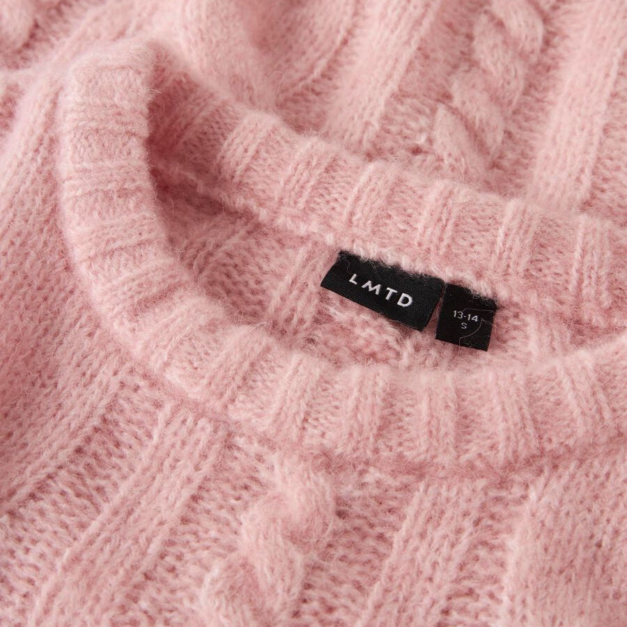 Close-up of a pink knitted fabric with a brand label.