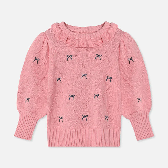 Pink sweater with black bow patterns on a light gray background