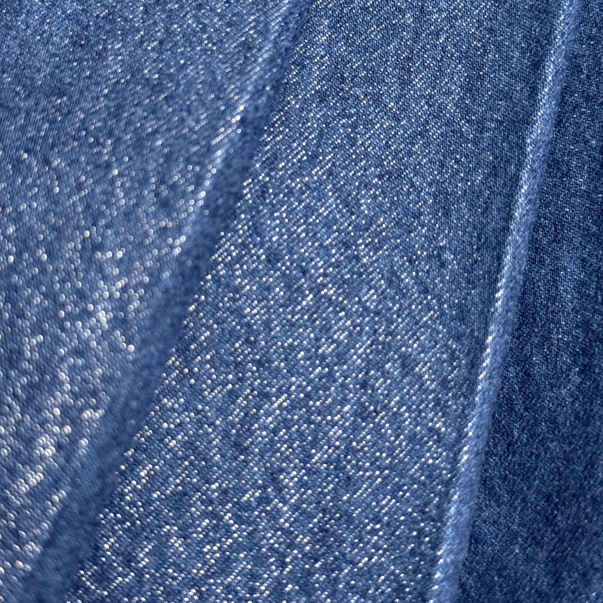 Närbild på jeanskjolensa glitterskimmer i tyget