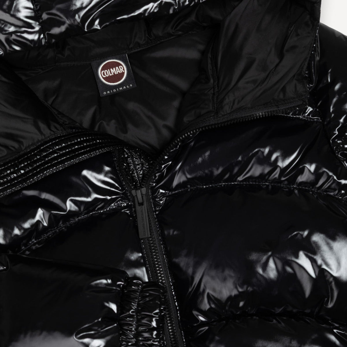 Close-up of a black puffer jacket with a Colmar brand logo on the chest.