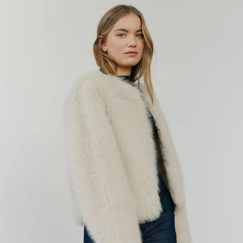 Young woman wearing a faux fur coat and denim pants