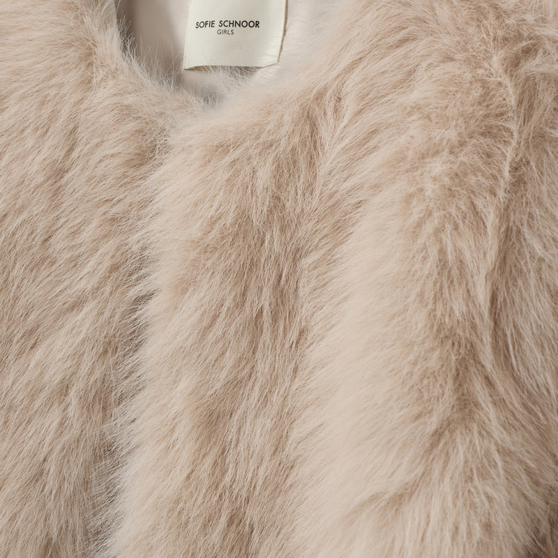 Close-up of a beige faux fur garment with Sofie Schnoor brand label.