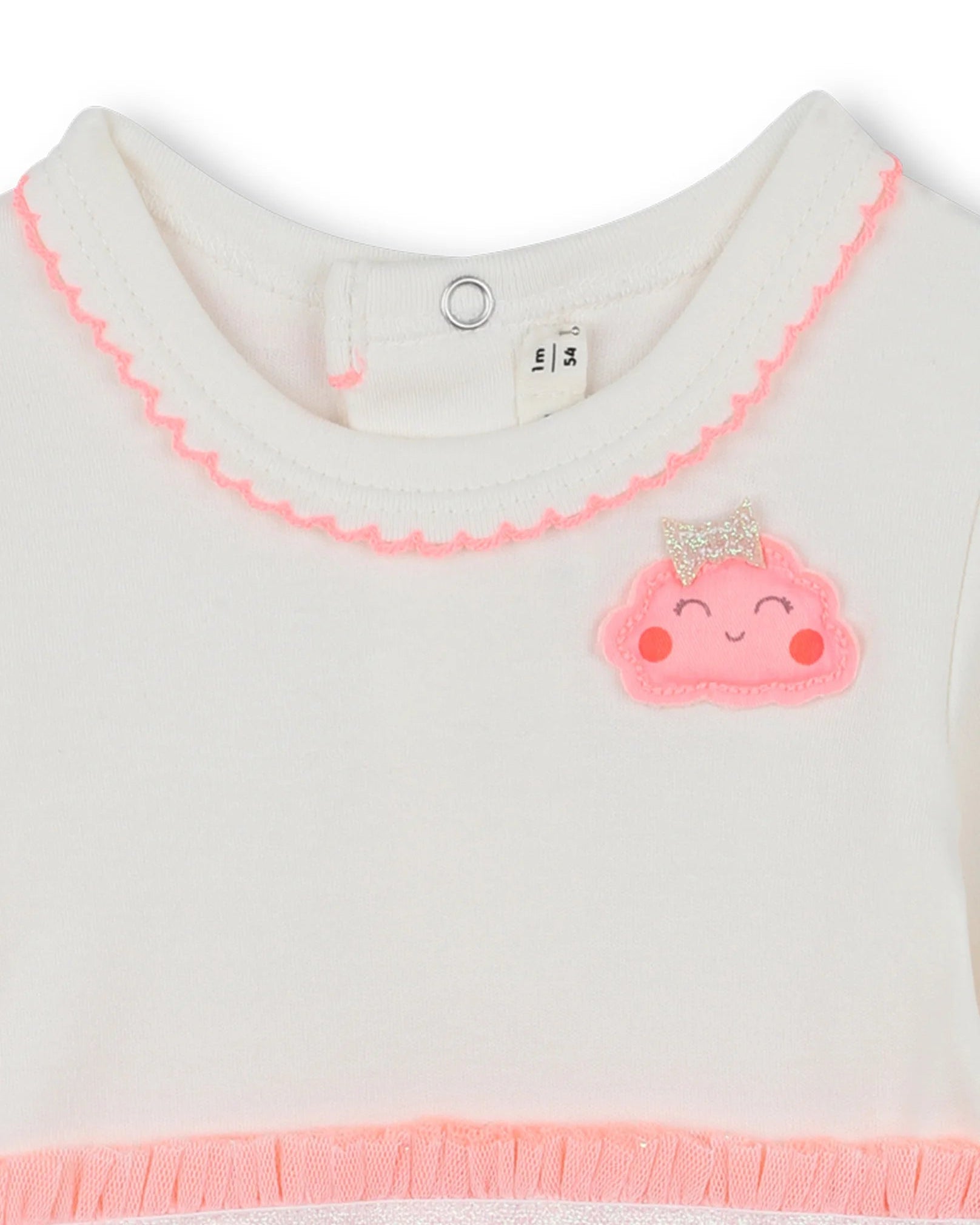 Close-up of a baby outfit with pink trim and a smiley face design on a white background