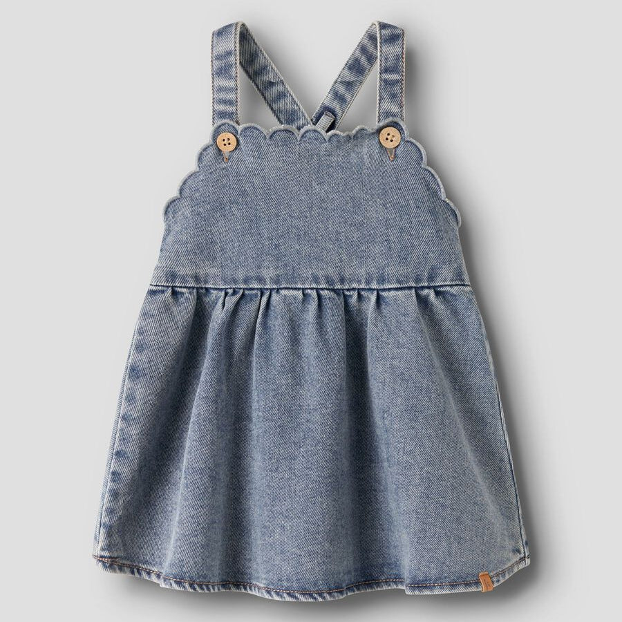 Blue denim pinafore dress on a light gray background