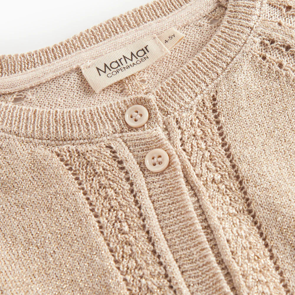 Close-up of a beige knitted cardigan with button details and a brand label.