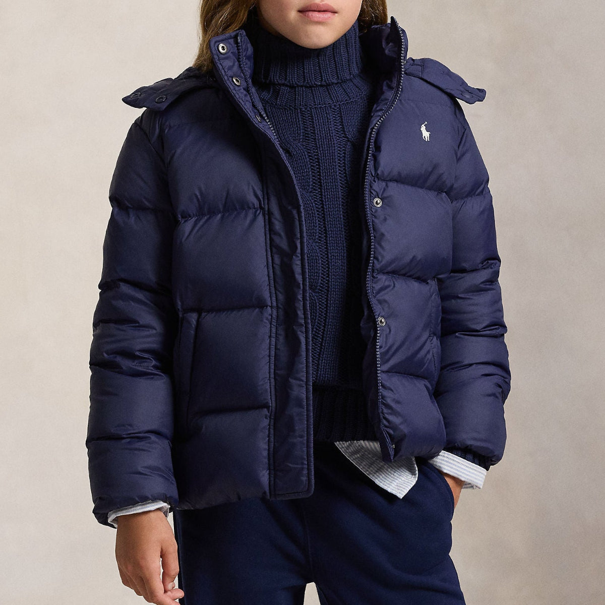 Tonårstjej iklädd mörkblå puffer/dunjacka från Polo Ralph Lauren