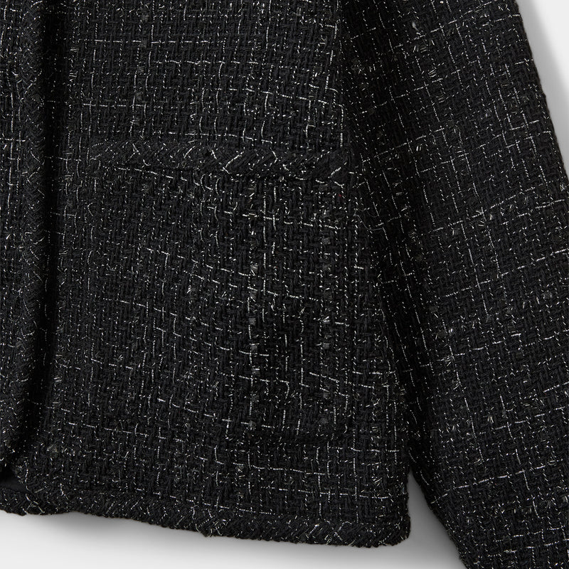 Close-up of a textured black fabric with a pocket detail on a white background