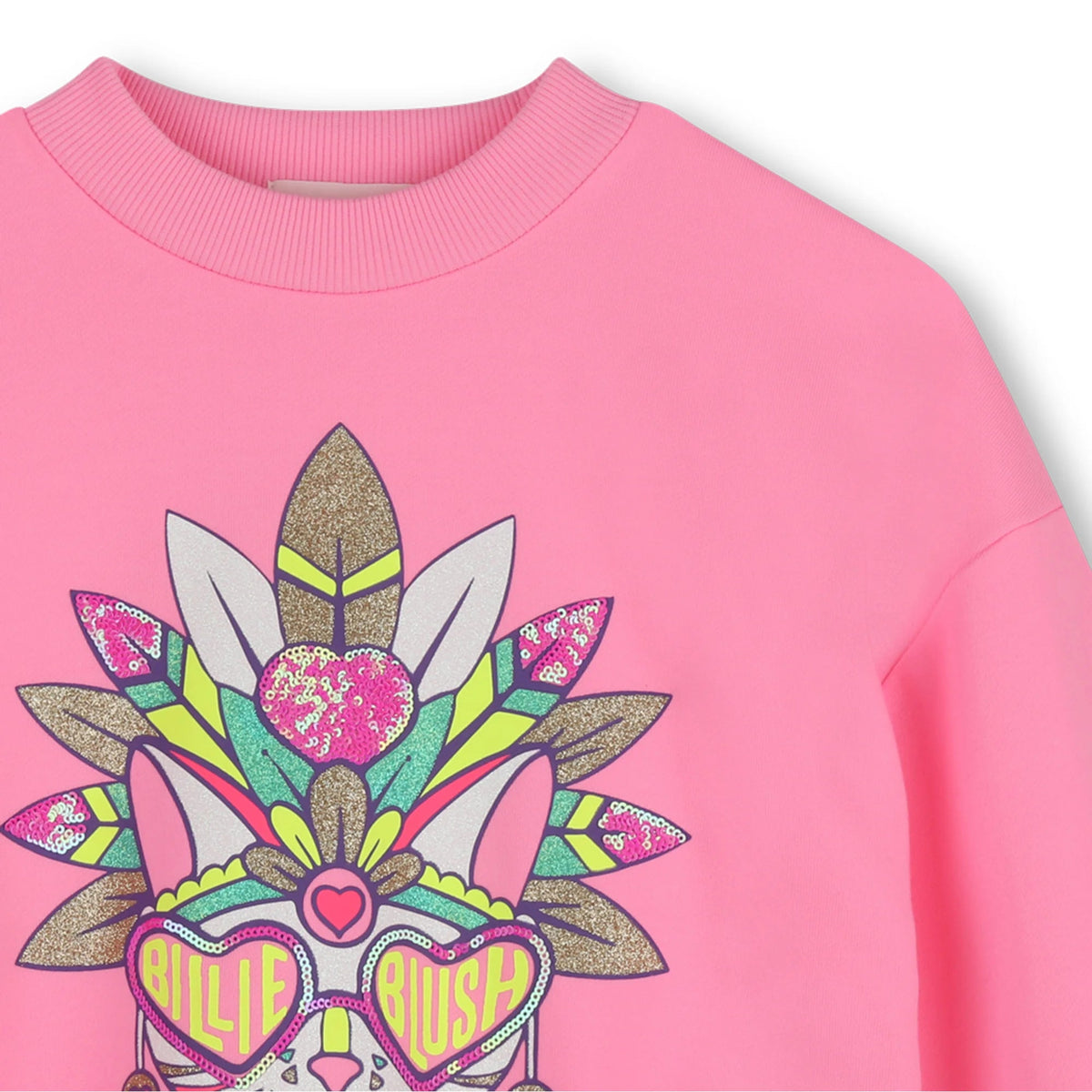 A close-up of a pink crewneck sweatshirt featuring a colorful graphic print of a stylized rabbit wearing heart-shaped sunglasses and a feathered headdress.