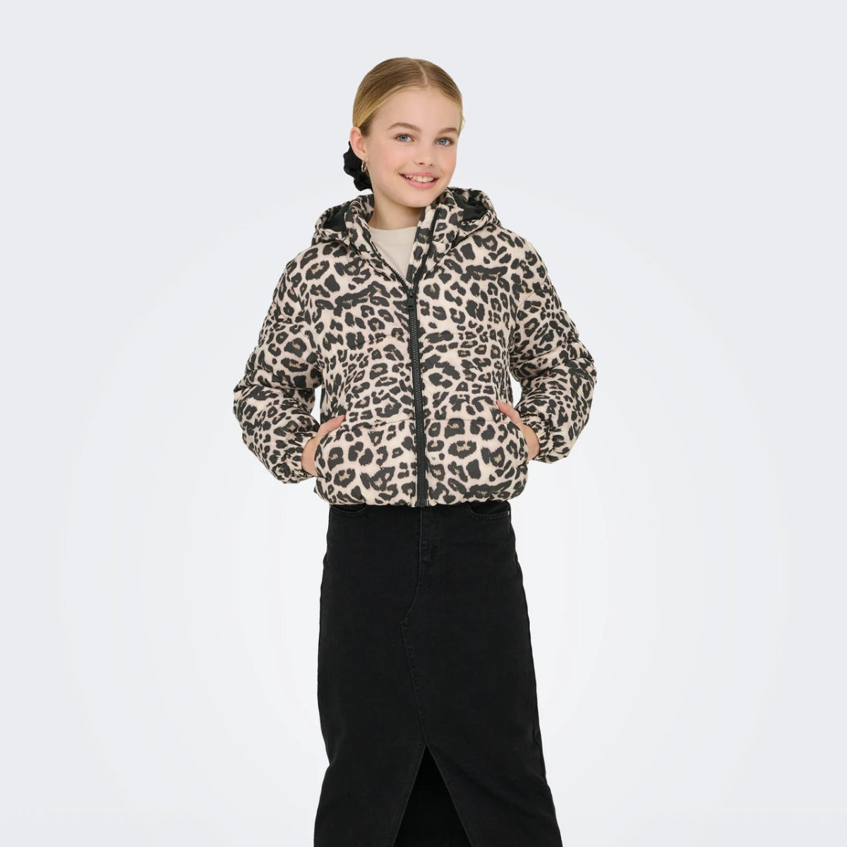 girl wearing a leopard print jacket and black skirt on a white background