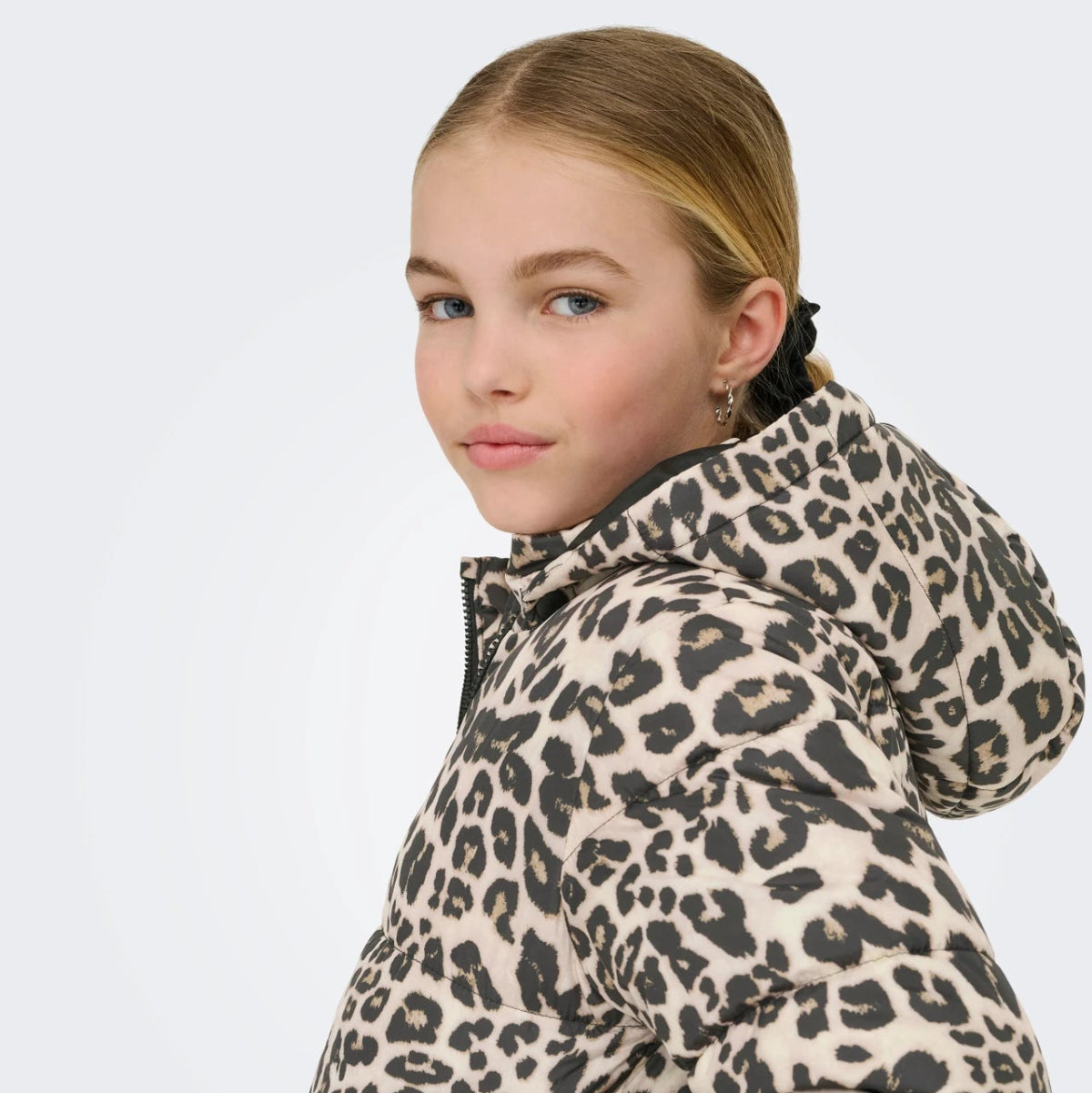 Child wearing a leopard print jacket on a white background