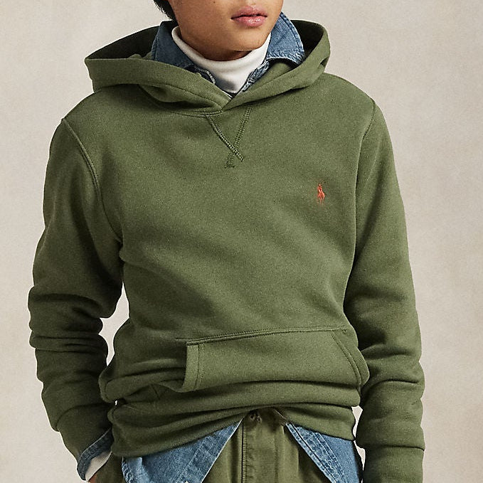 Boy wearing a green hoodie and pants with a plain background
